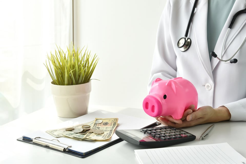 Doctor Holding Piggy Bank